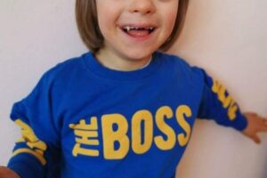 Wychowanek pozuje w niebieskiej koszulce - symbolu autyzmu