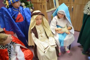Zdjęcie przedstawia 3 dzieci przebranych za Maryję, Józefa oraz Mędrca.