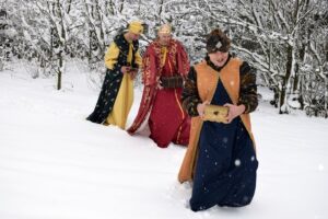 Na zdjęciu widocznych jest 3 osoby. Idą zaśnieżoną drogą. Przebrani są za 3 Króli, którzy udają się do Jezusa.