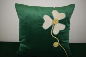 Na zdjęciu widoczna jest poduszka z ręcznie haftowanym kwiatem.