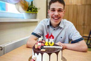 Na zdjęciu widoczny jest jubilat Wojtek z tortem urodzinowym