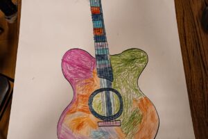 Na zdjęciu widac pracę plastyczną - kolorową gitarę