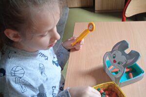 Na zdjęciu wychowanka gra w grę edukacyjną związaną z marchewką