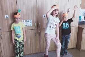 Na zdjęciu wychowankowie stoją w marchewkowych czapkach
