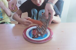 Na zdjęciu wychowanek i opiekun trą marchewkę