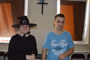 Na zdjęciu widoczne są 2 osoby. Dziewczyna i chłopak. Dziewczyna ma ubrany kapelusz czarownicy.