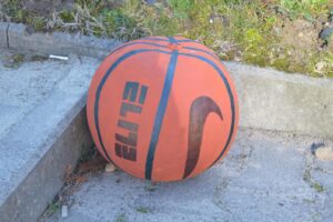 Na zdjęciu widoczna jest dynia, która została pomalowana farbami. Przypomina piłkę do koszykówki.