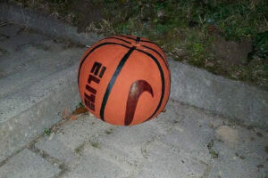 Na zdjęciu widoczna jest dynia, która została pomalowana farbami. Przypomina piłkę do koszykówki.