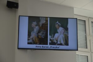 Na zdjęciu widoczny jest ekran, na którym wyświetlono jedną z prac konkursowych w zestawieniu z obrazem.