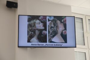 Na zdjęciu widoczny jest ekran, na którym wyświetlono jedną z prac konkursowych w zestawieniu z obrazem.